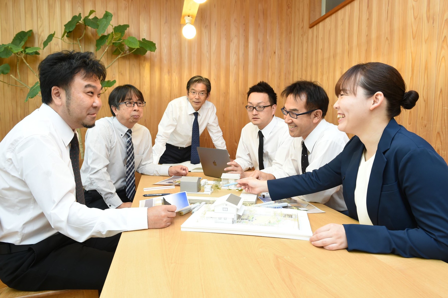 模型や資料を囲んでプランを検討する小林建設のスタッフ